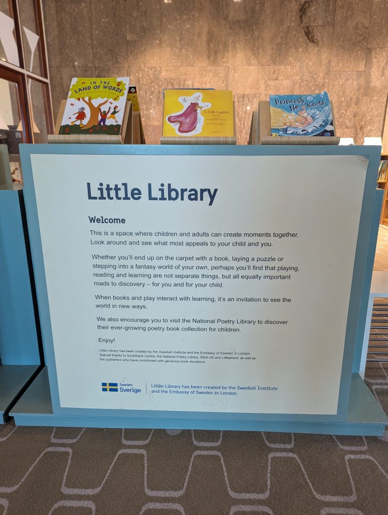 A children's picture book display above a sign saying "Little Library" - Welcome.