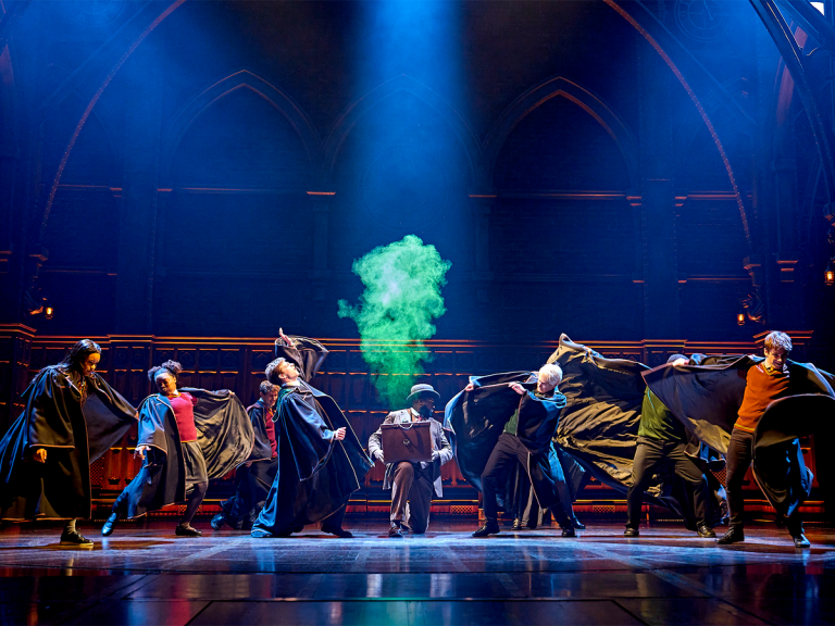 The cast of Harry Potter and the Cursed Child casting a spell with a puff of green smoke